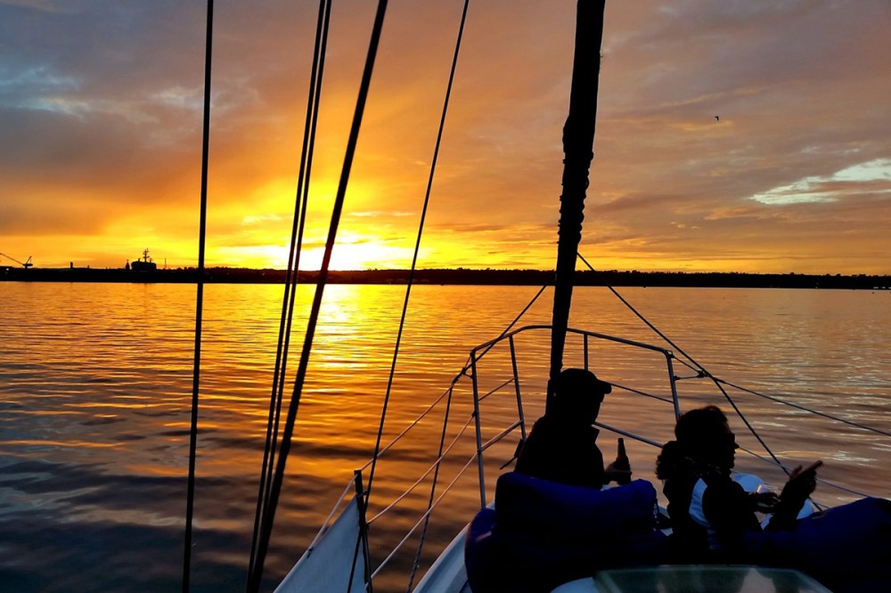 a group of people sitting in a boat on a body of water